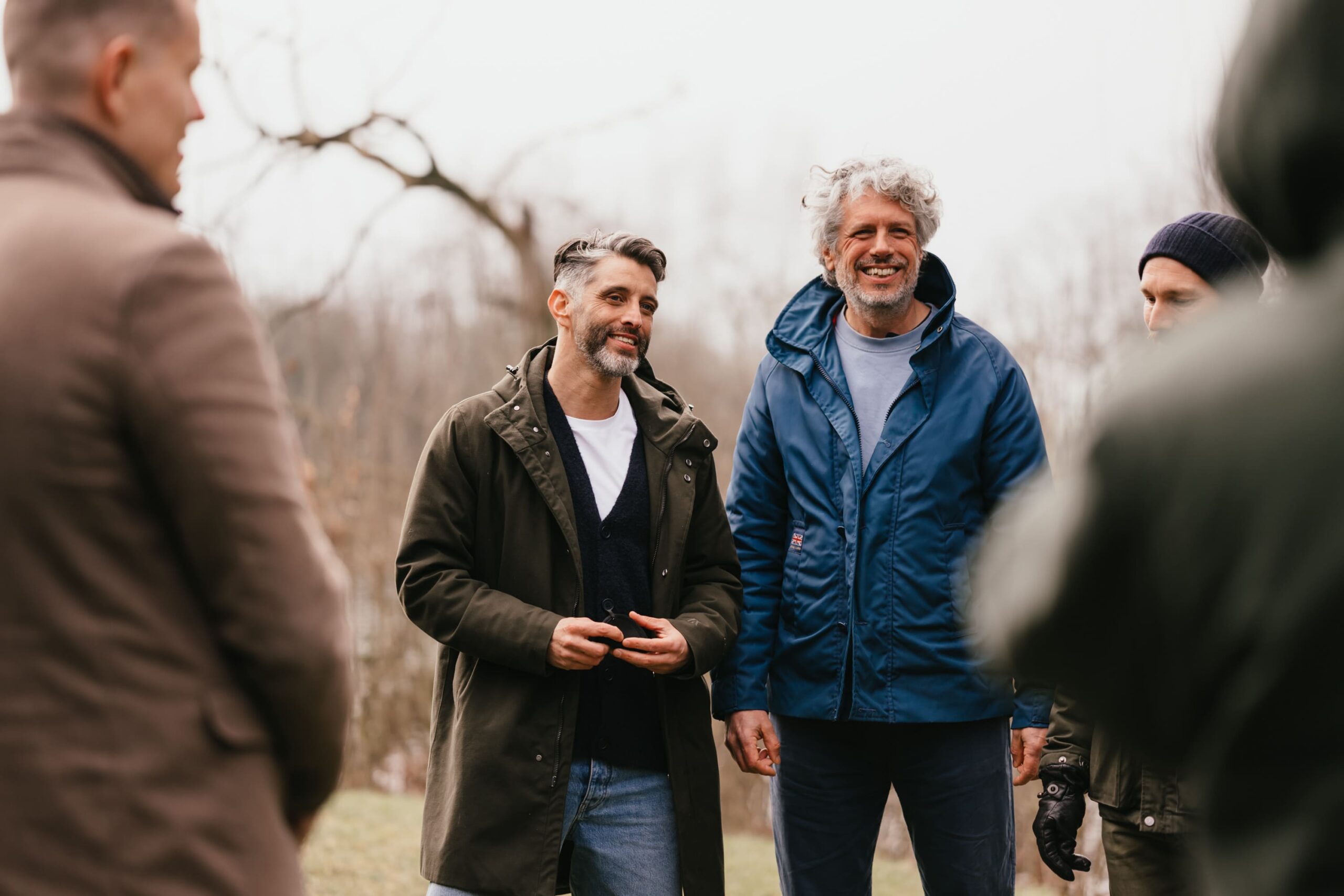 Sharief en De Mannen Cirkel staan in een kring en lachen